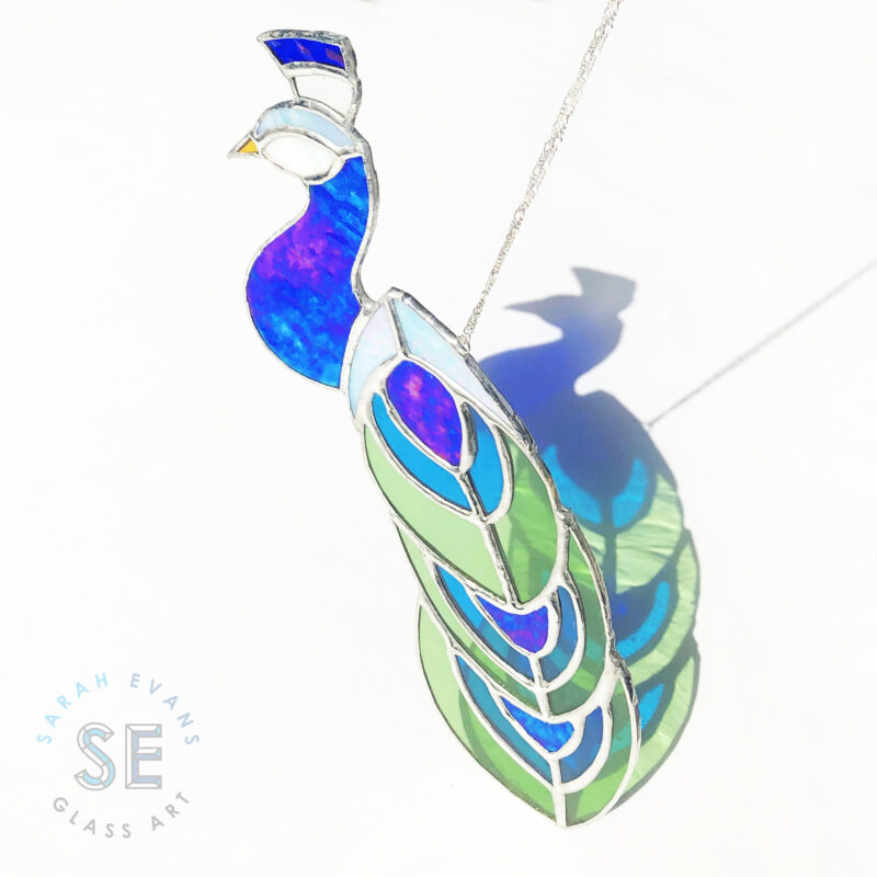 Sarah Evans Glass Art Stained Glass Peacock. Handmade in Bath, Ontario. Shop our unique selection of stained glass jewelry, gifts and home decor. #sarahevansglassart #stainedglass #glassart #windowart #suncatchers #homedecor #uniquegifts #handmadegifts #bathontario